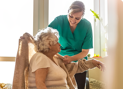 Caregiver assisting elderly woman with arm exercises at home.